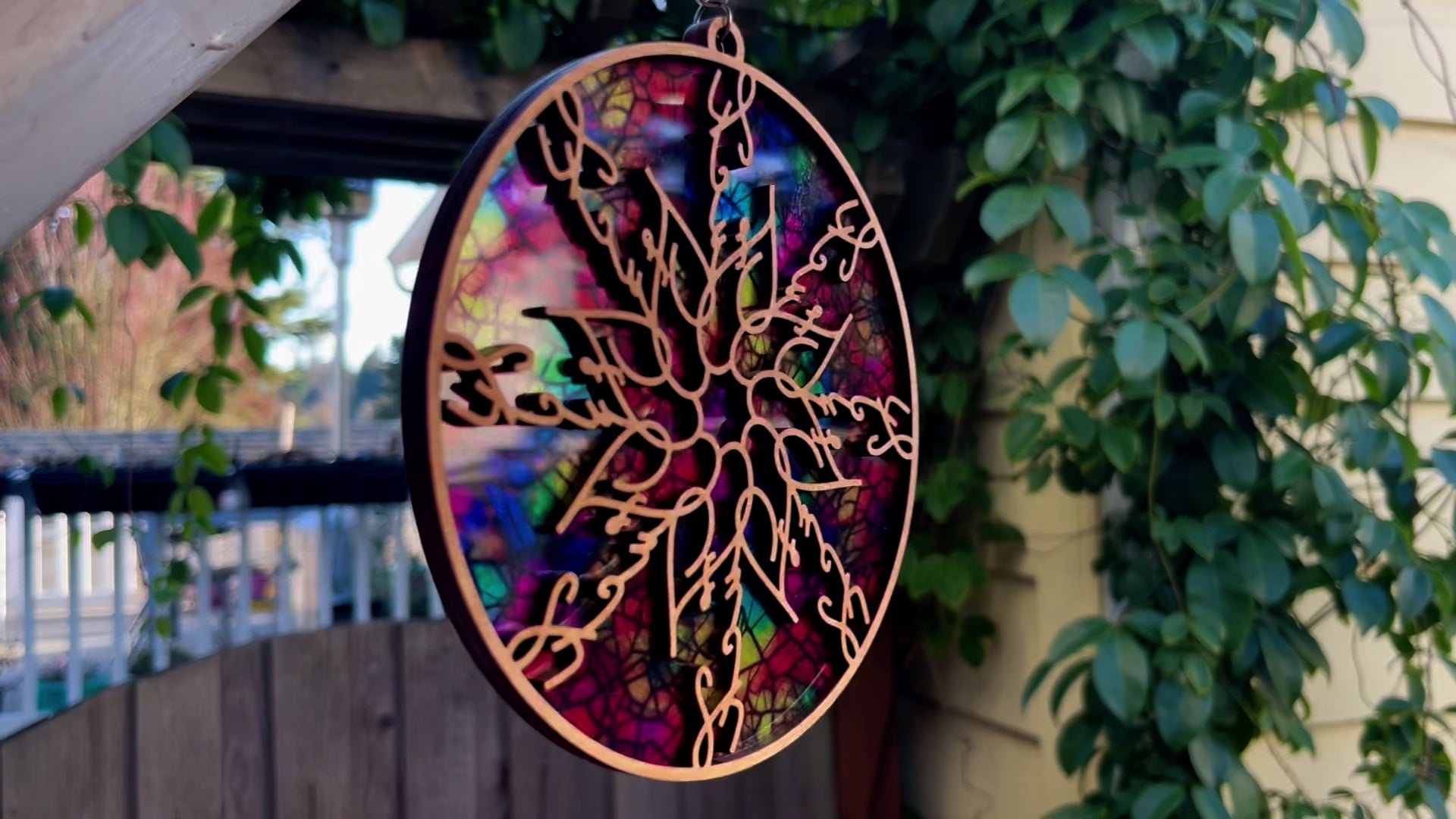 A suncatcher that says "Fuck" in cursive, spinning in a light breeze.