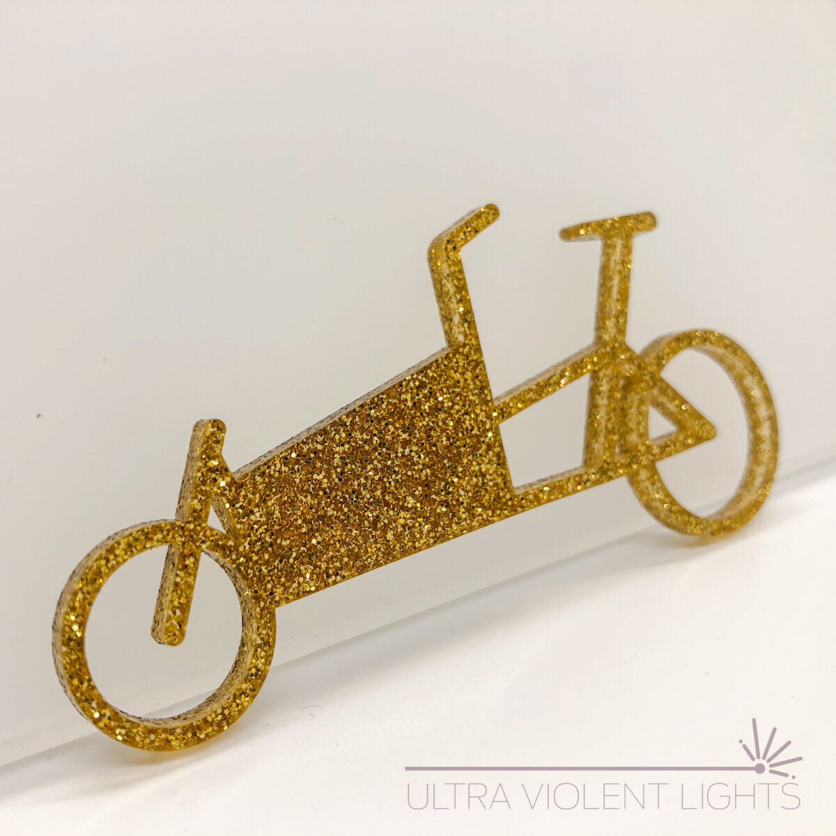 A box bike figure in gold acrylic