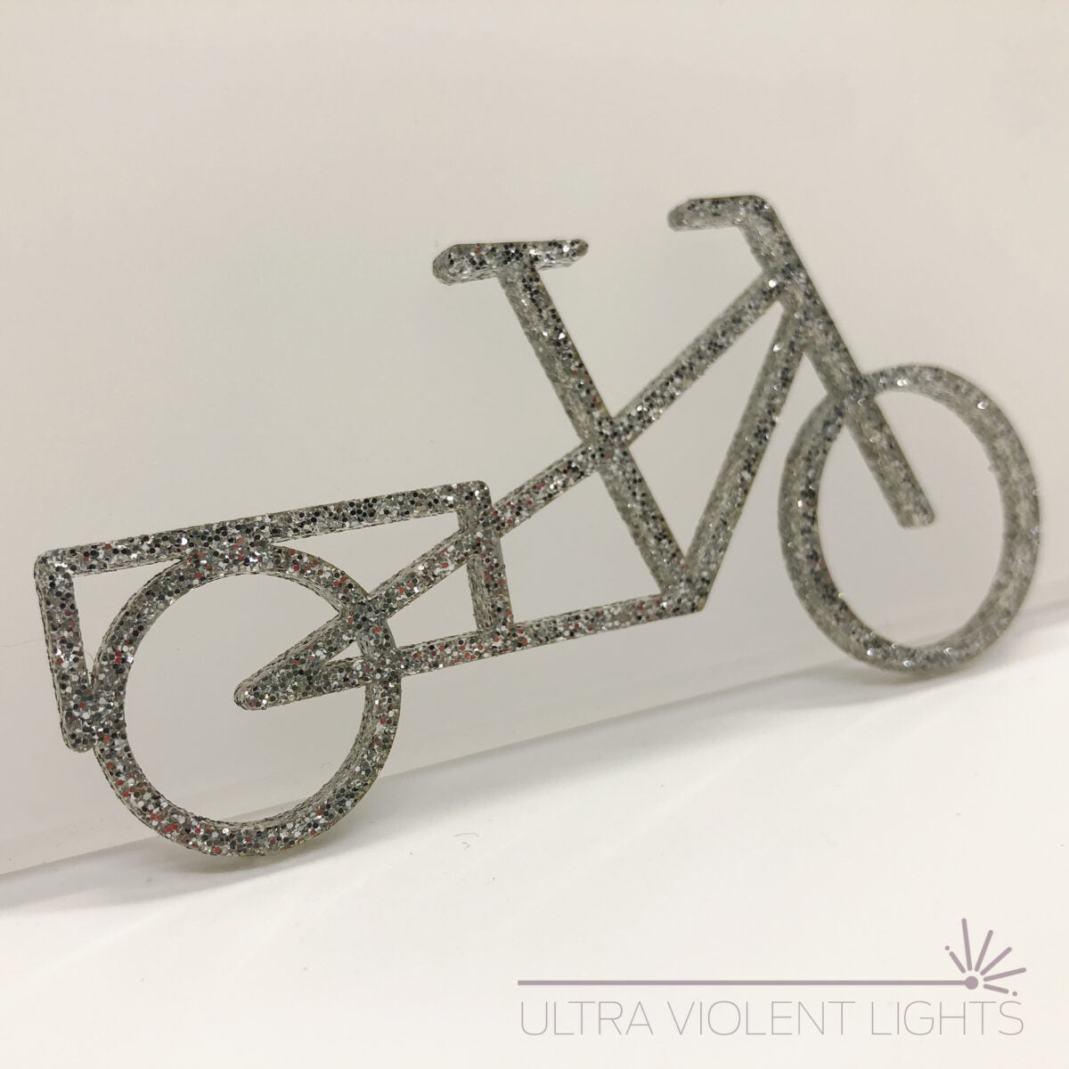 A longtail bike figure in silver acrylic