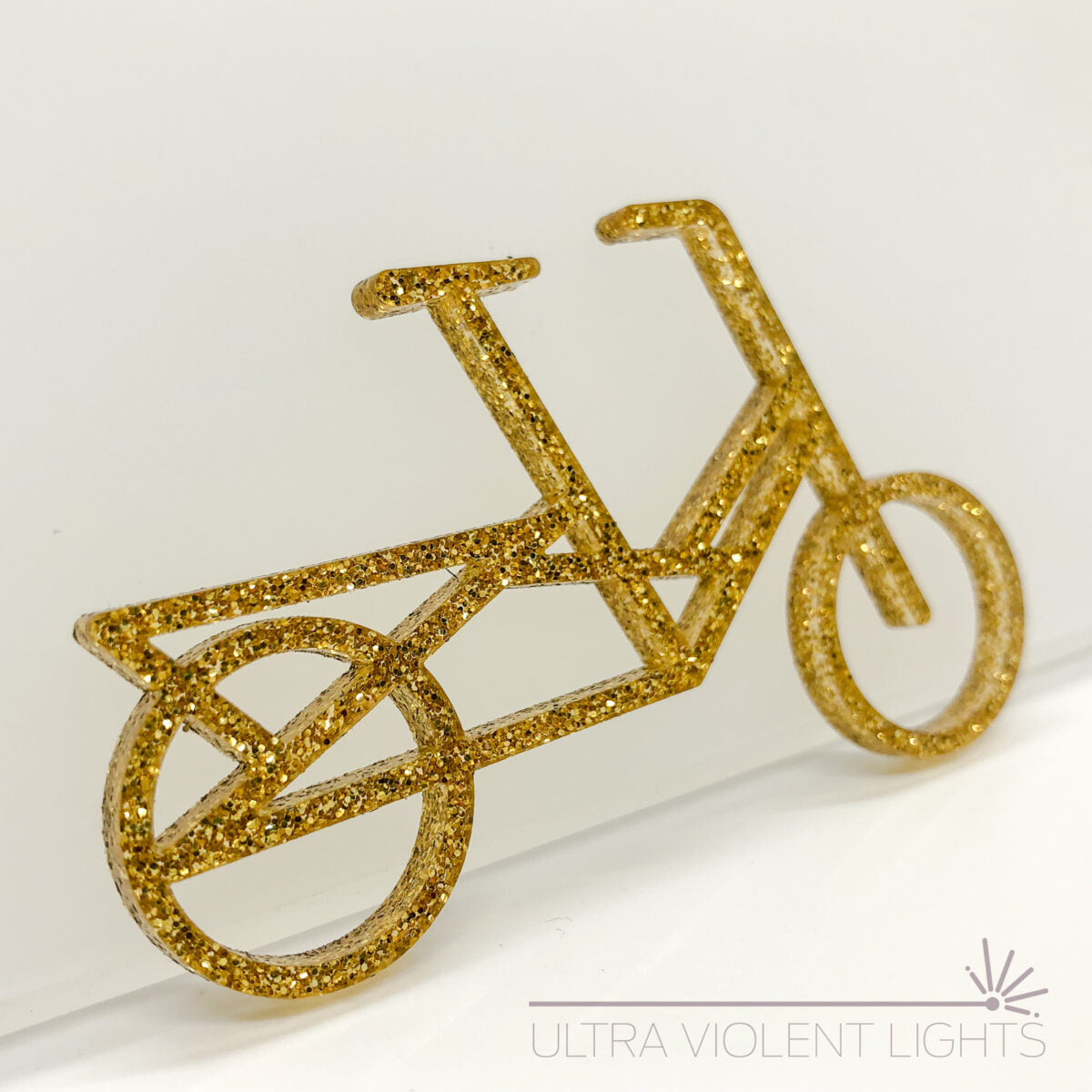 A Midtail bike figure in gold acrylic