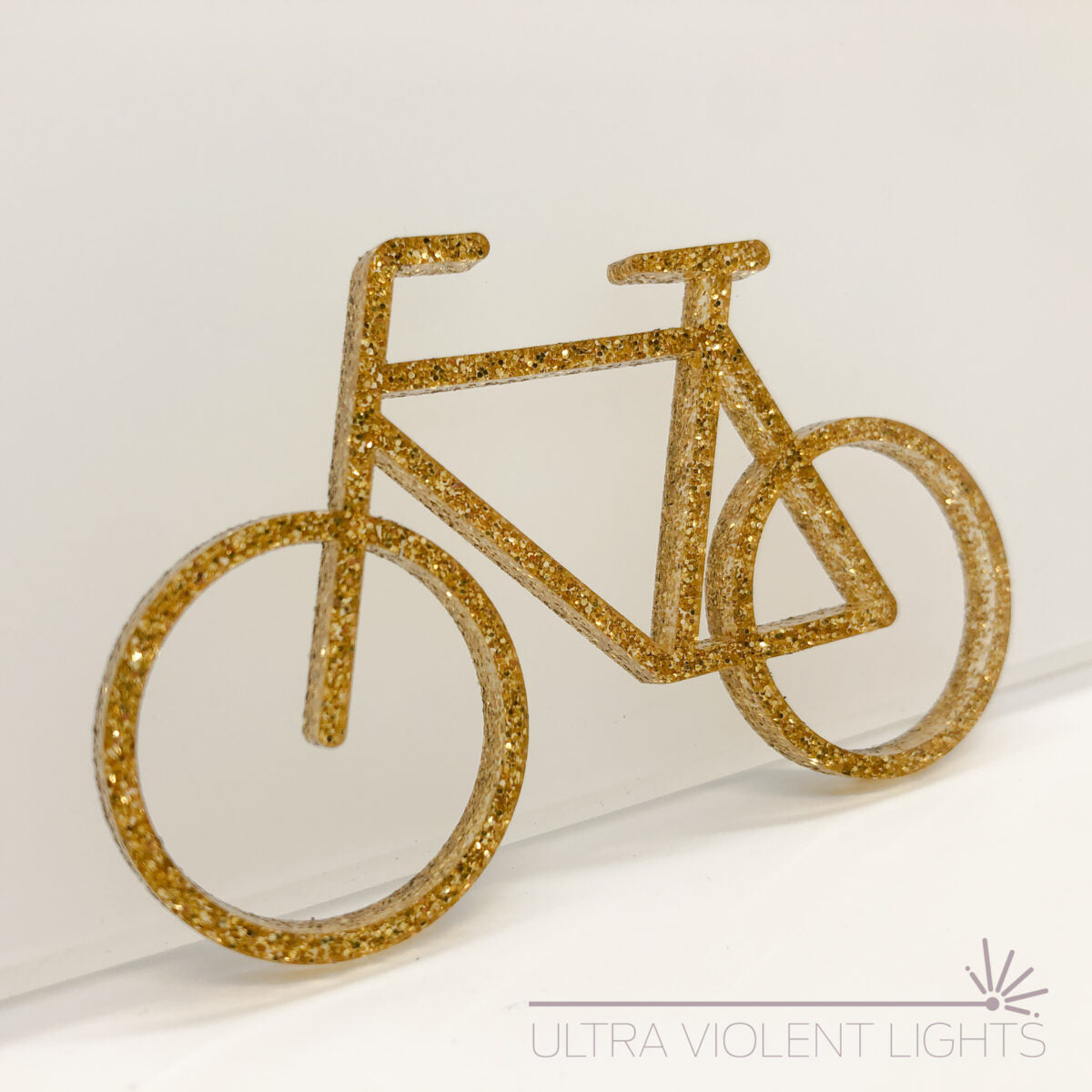 A single bike figure in gold acrylic