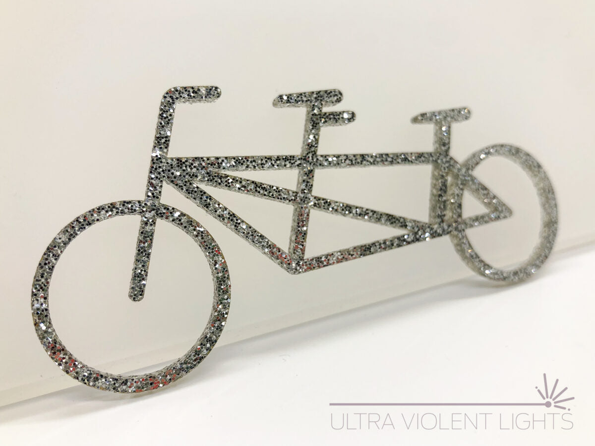 A tandem bike figure in silver acrylic