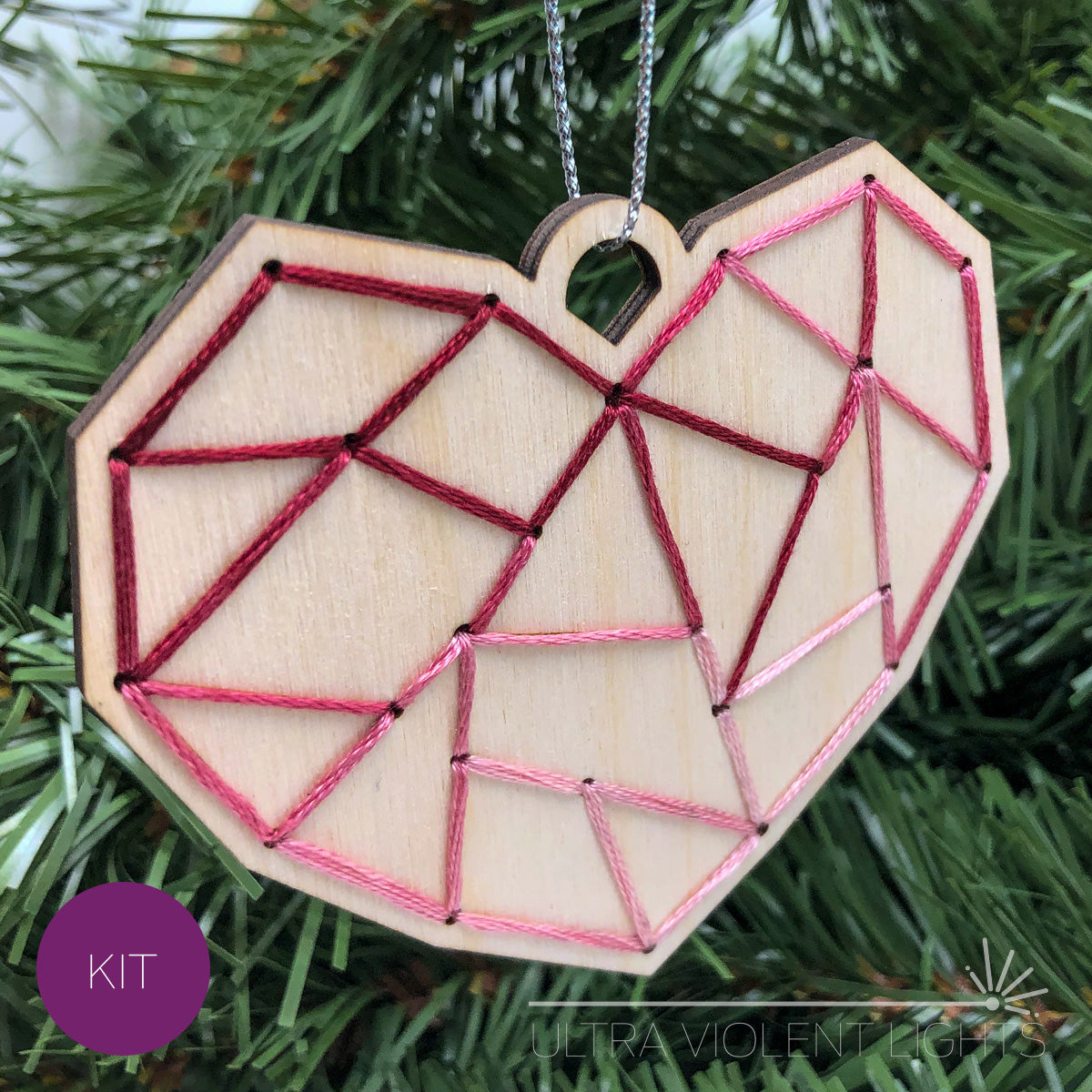 Heart embroidered wood ornament on greenery