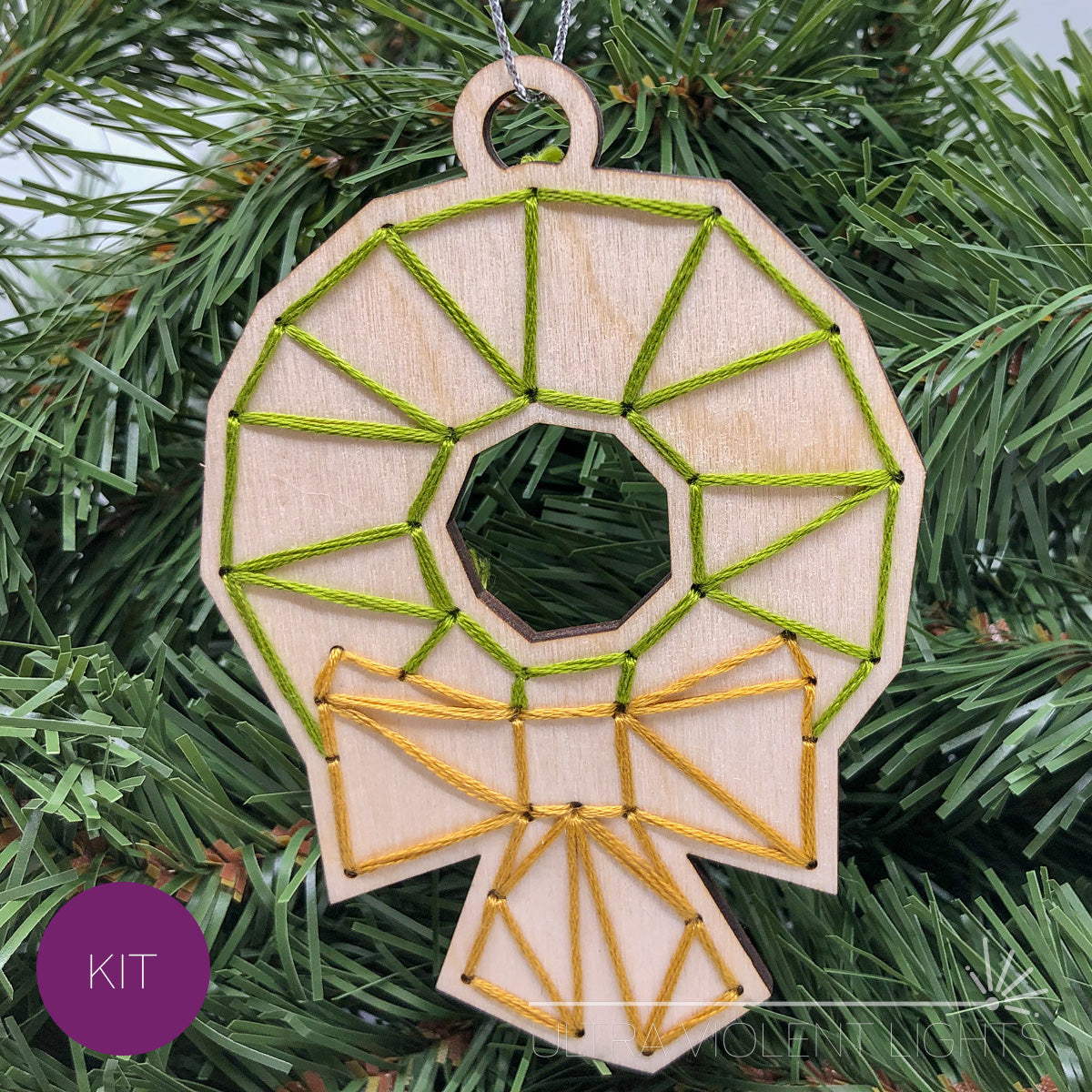 Wreath embroidered wood ornament on greenery