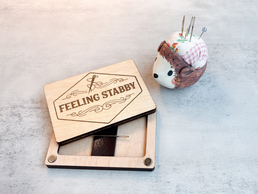 An open needle minder engraved with “feeling stabby”