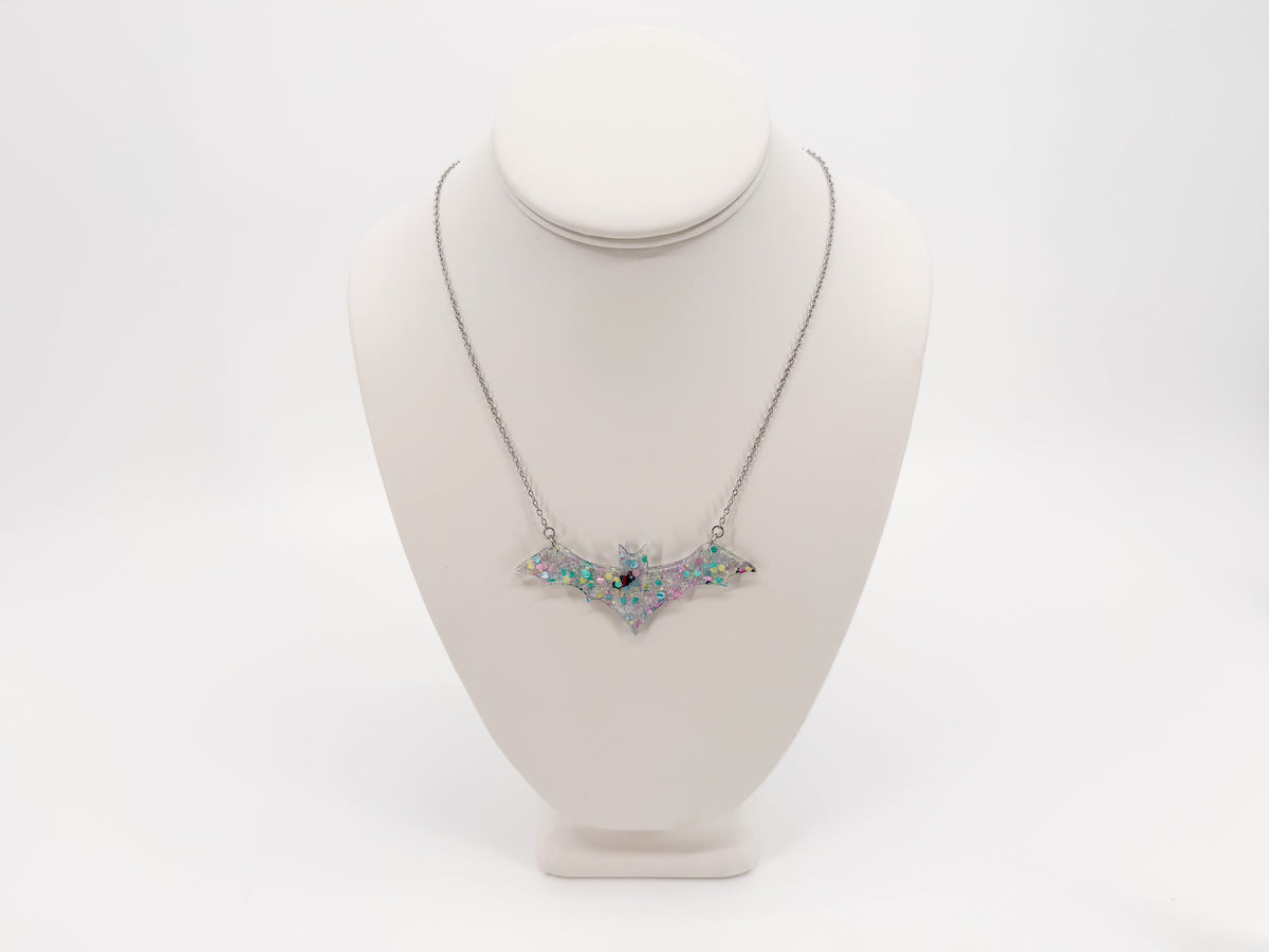 Pastel confetti acrylic bat necklace with a silver-tone chain shown in full on a white display bust.