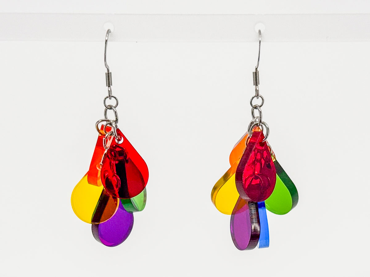 A pair of dangling earrings with multiple translucent rainbow-colored teardrop shapes attached to silver fishhook wires, shown against a plain white background.