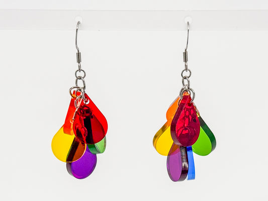 A pair of dangling earrings with multiple translucent rainbow-colored teardrop shapes attached to silver fishhook wires, shown against a plain white background.