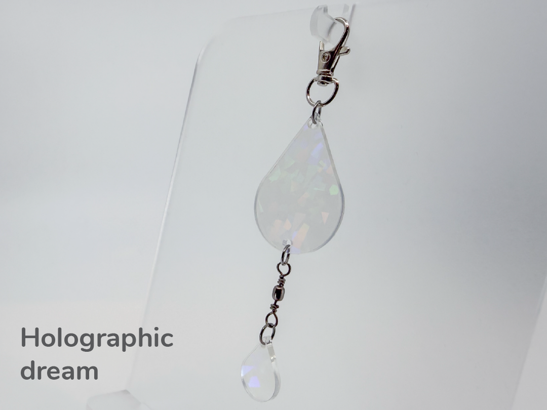 Holographic iridescent clear teardrop-shaped small sun catcher / keychain on a white background