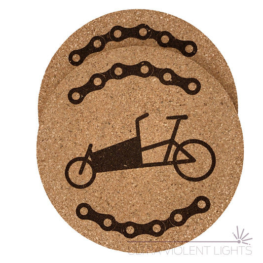 Two cork coasters engraved with bike chains and a box bike and