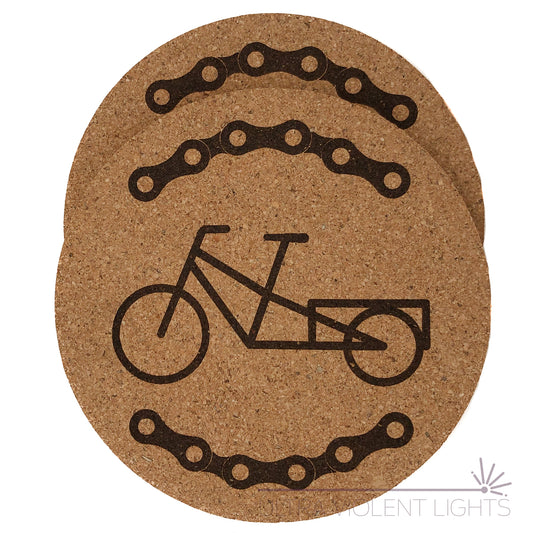 Two cork coasters engraved with bike chains and a long tail bike