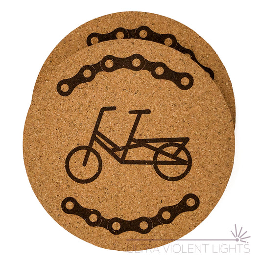Two cork coasters engraved with bike chains and a Midtail bike