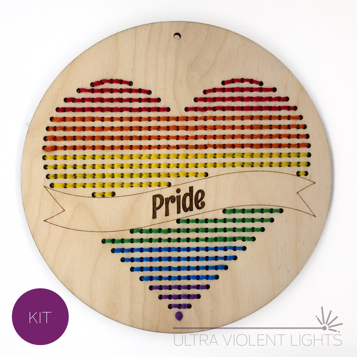 A heart embroidery kit done up in a rainbow, reading "Pride."