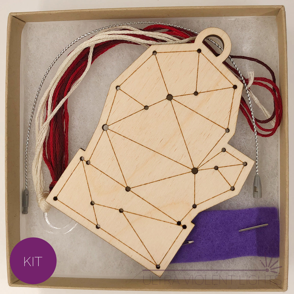A mitten wooden embroidery kit with floss and a needle in a box