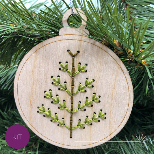 Spiky tree embroidered wood ornament on greenery