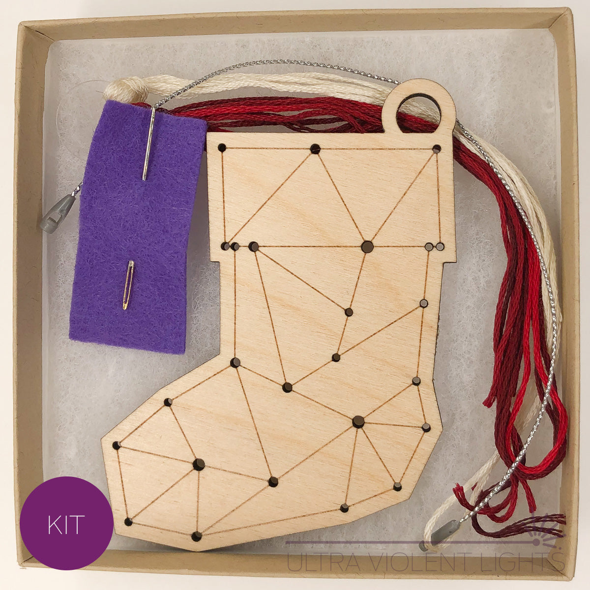 A stocking wooden embroidery kit with floss and a needle in a box