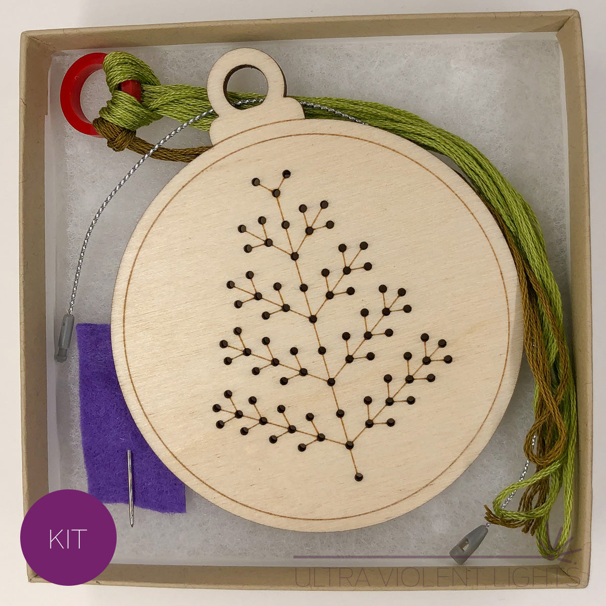 A spiky tree wooden embroidery kit with floss and a needle in a box